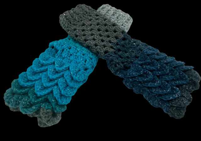 A pair of crochet fingerless gloves using the crocodile stitch. The color is blues and greys, nicknamed Stardust.
