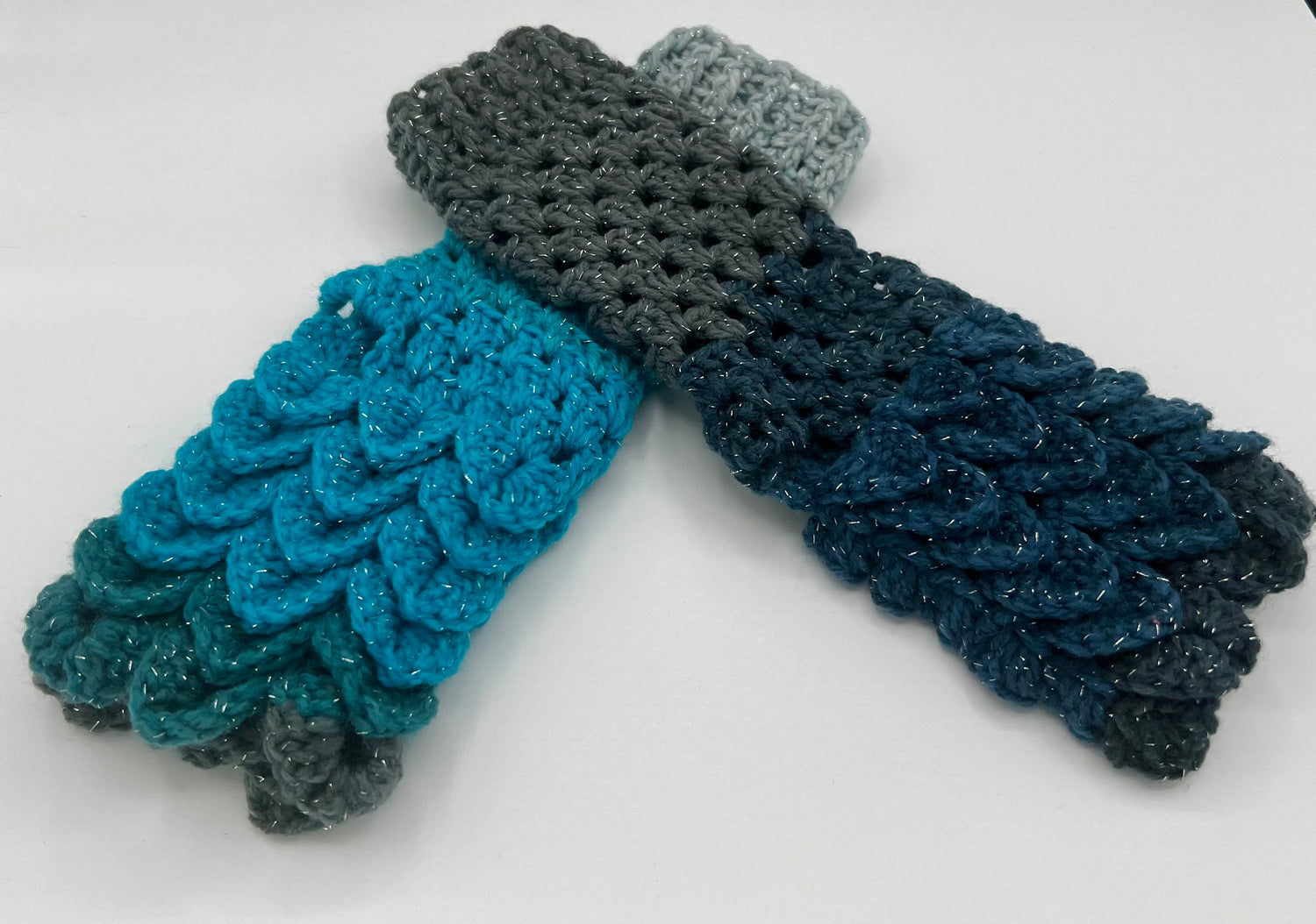 A pair of crochet fingerless gloves using the crocodile stitch. The color is blues and greys, nicknamed Stardust.